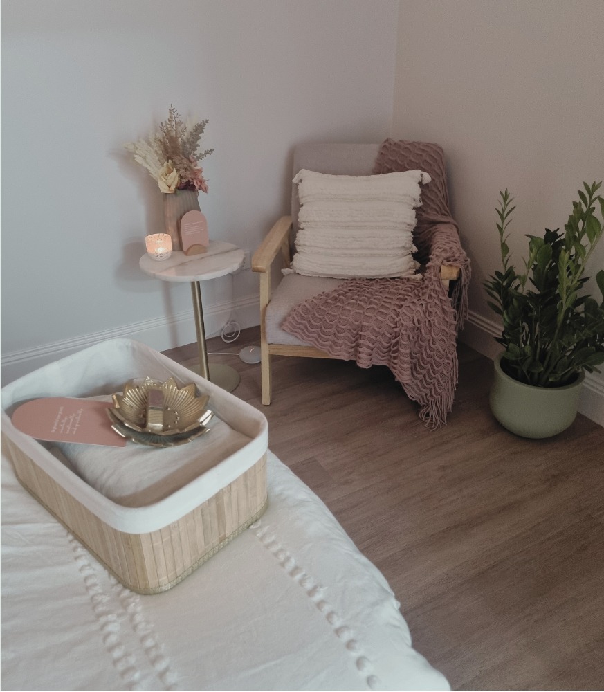 The treatment room at Rejuvenate, with an armchair, a marble side table and a candle